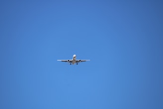 low angle photography of gray airplane under blue sky at daytime