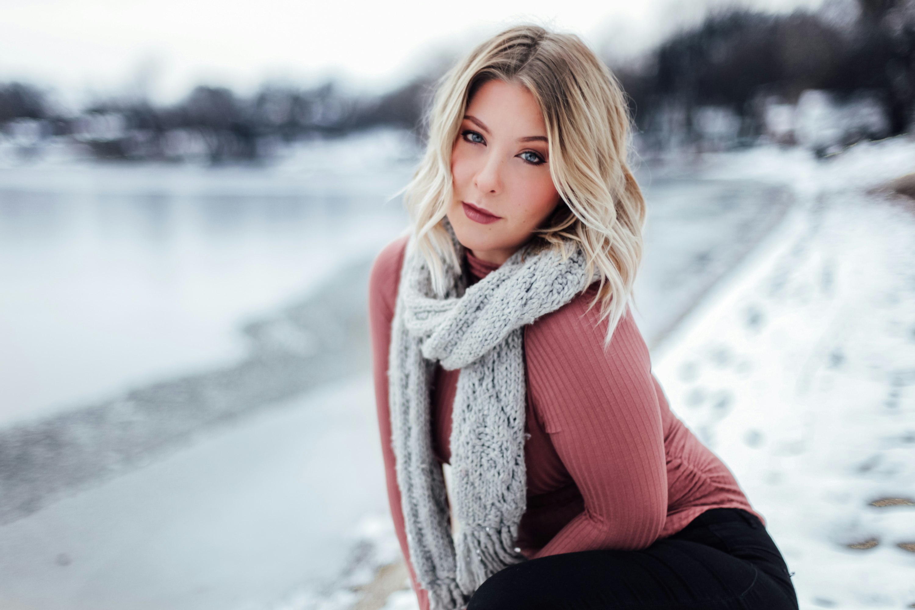 woman with gray scarf near body of water during daytime