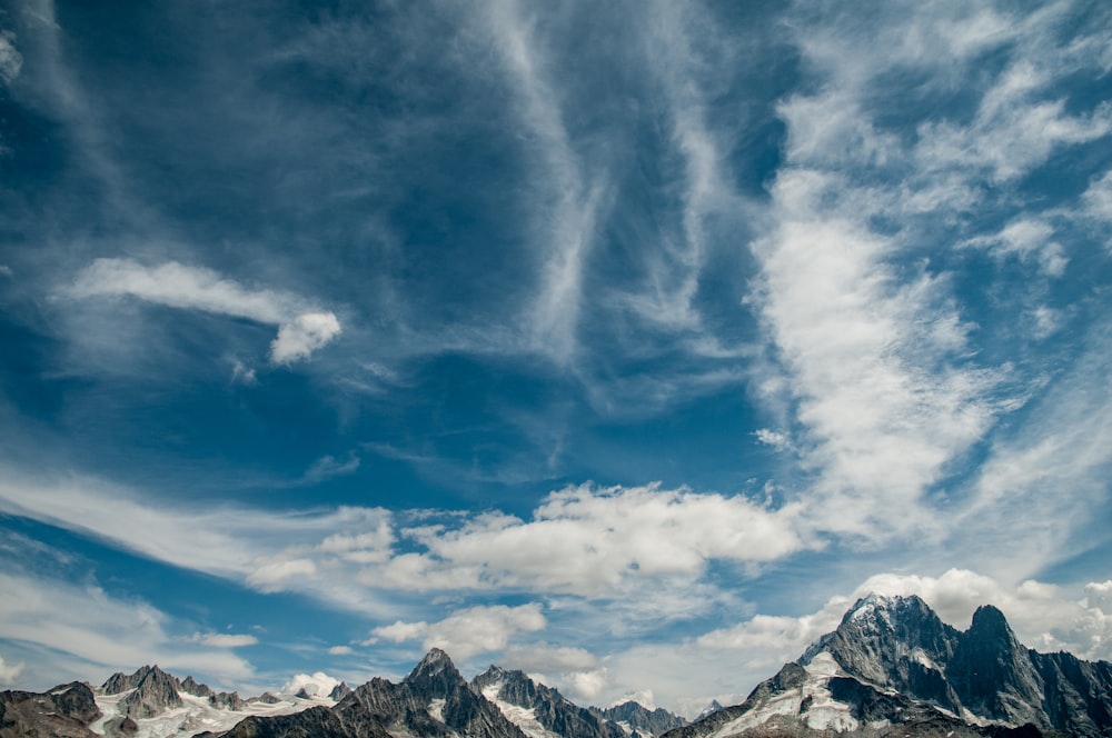 mountain under cirrus clouds during daytime