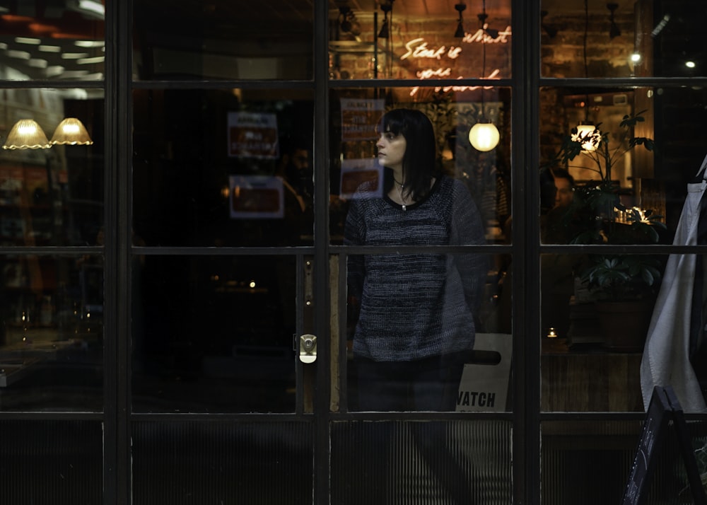 woman standing near glass window