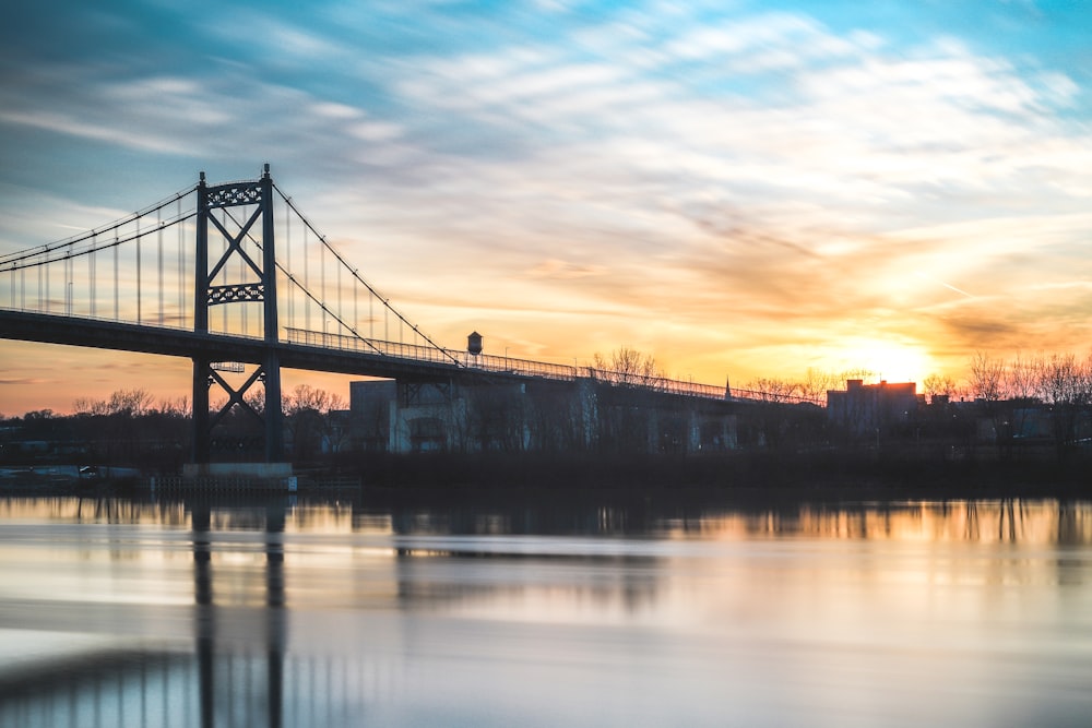 silhouette photo of suspension bridge photography during golden hour