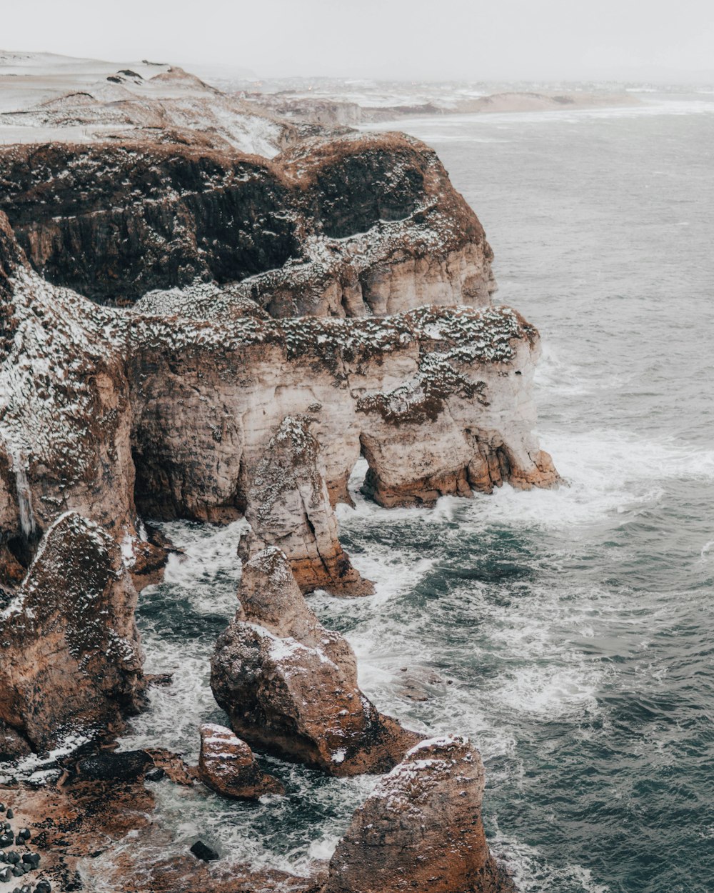 high angle photo of mountain rocks beside sea