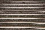 Concentric stone seating steps with moss growing in between, creating a textured and layered appearance. The alternating pattern of stone and brick is evident, with subtle natural wear adding character.