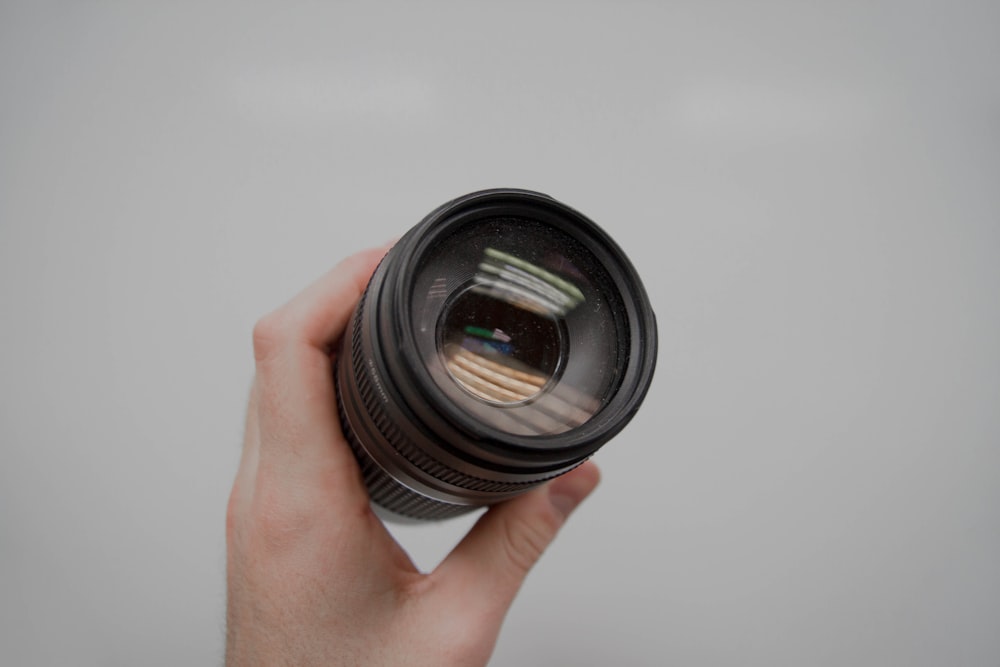 person holding black camera lens