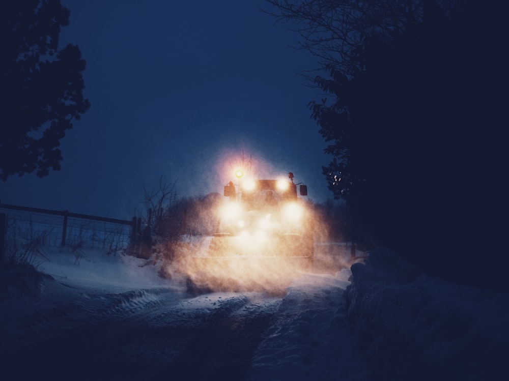 Fahrzeug nachts auf schneebedeckter Straße