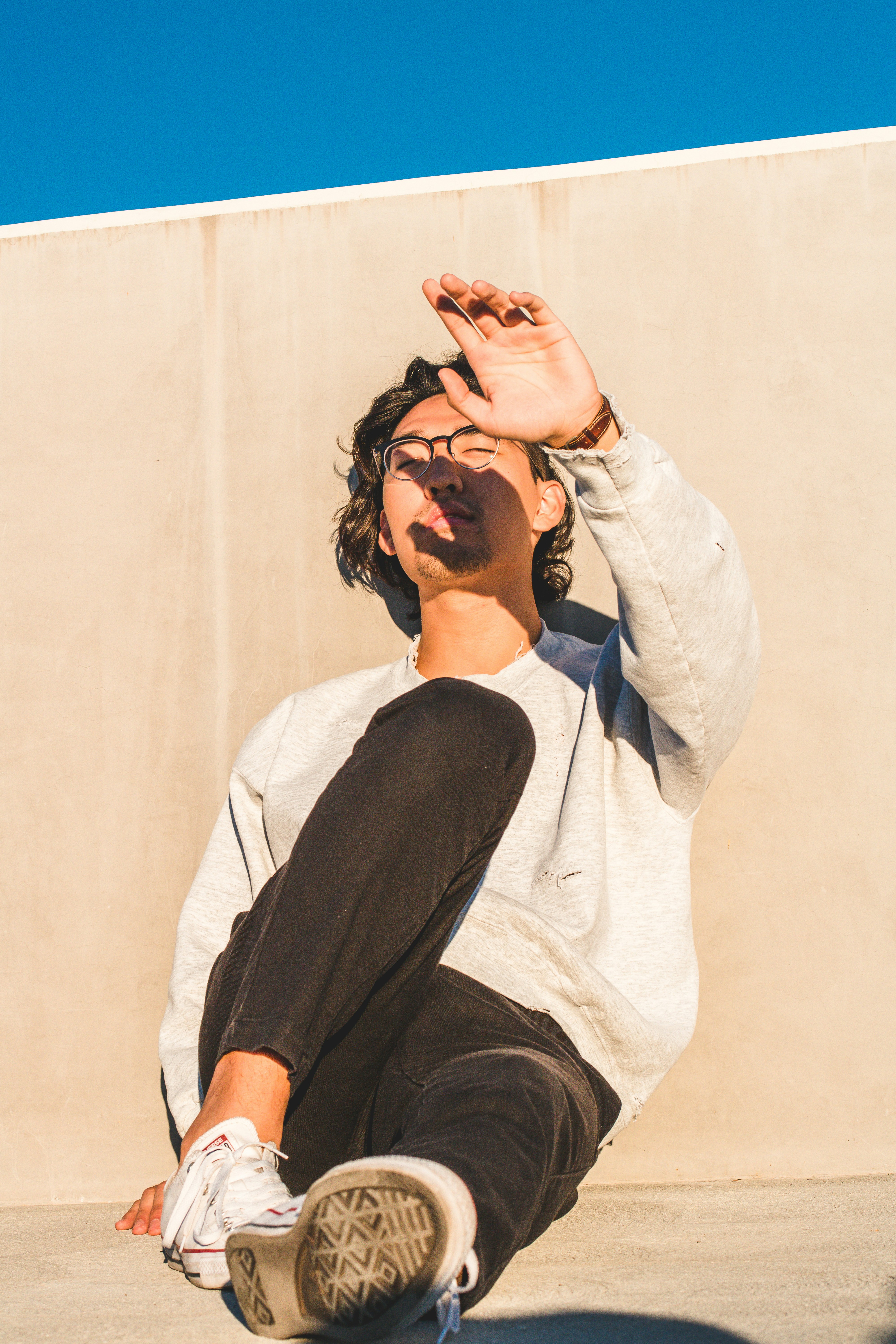 uomo seduto vicino al muro marrone