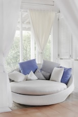 white cuddle chair and throw pillows near window