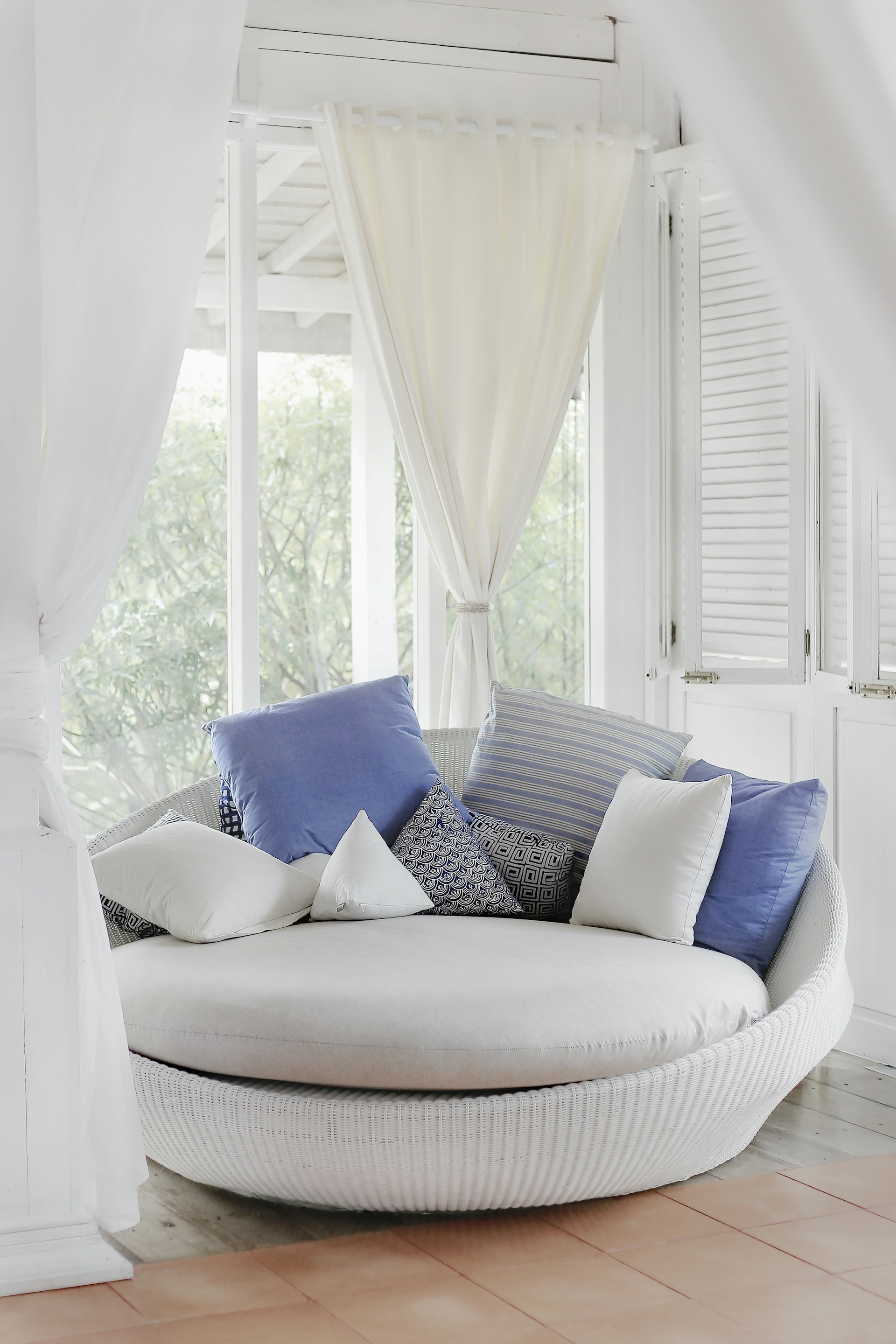 white cuddle chair and throw pillows near window