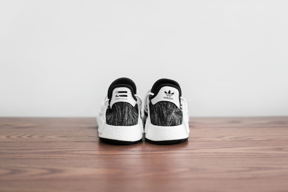 pair of white-and-black adidas shoes on wooden surface photo – Free Sneaker  Image on Unsplash