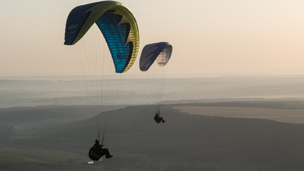 Foto time-lapse de dos personas saltando en paracaídas durante el día