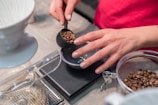 person scooping and measuring coffee beans