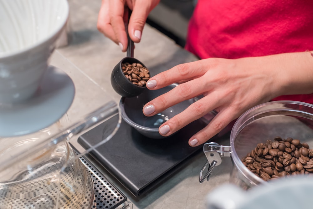 person scooping and measuring coffee beans