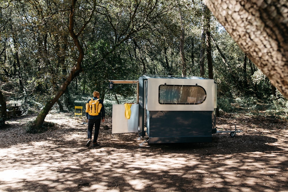 man standing beside enclosed trailer