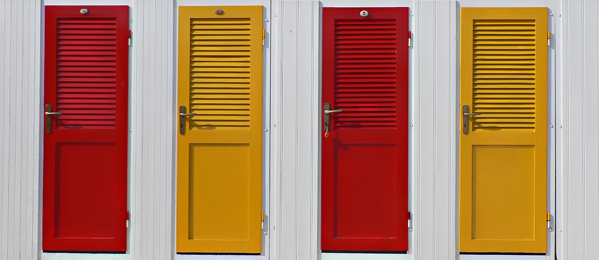 Four closed doors arranged symmetrically on a coloured wall, suggesting different paths or choices.