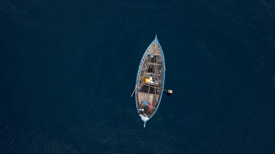 blue and brown boat on body of water in Lhaimagu Maldives