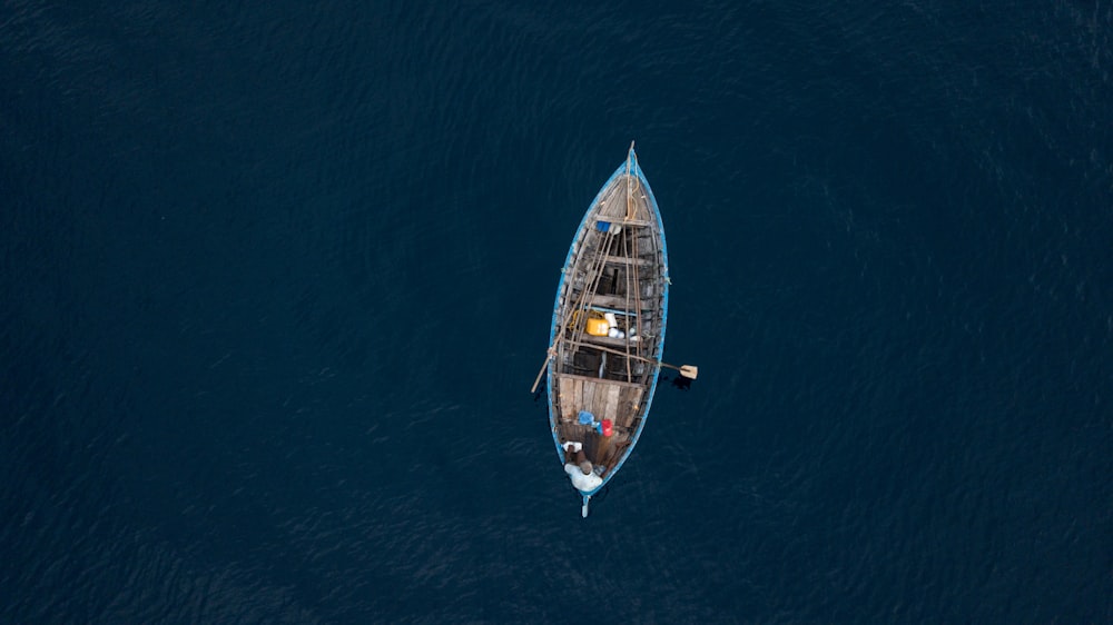 blue and brown boat on body of water