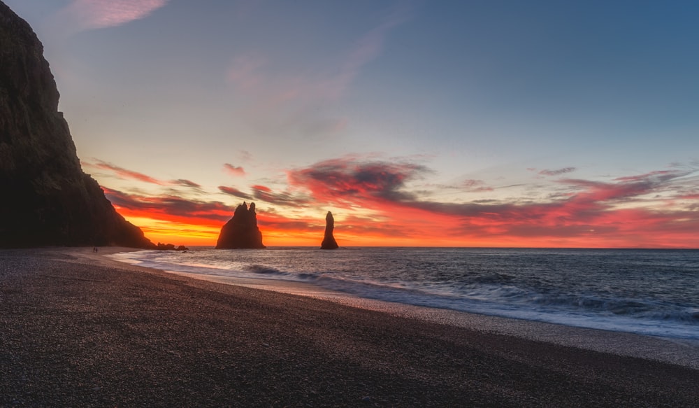 shore near rock formation at golden hour