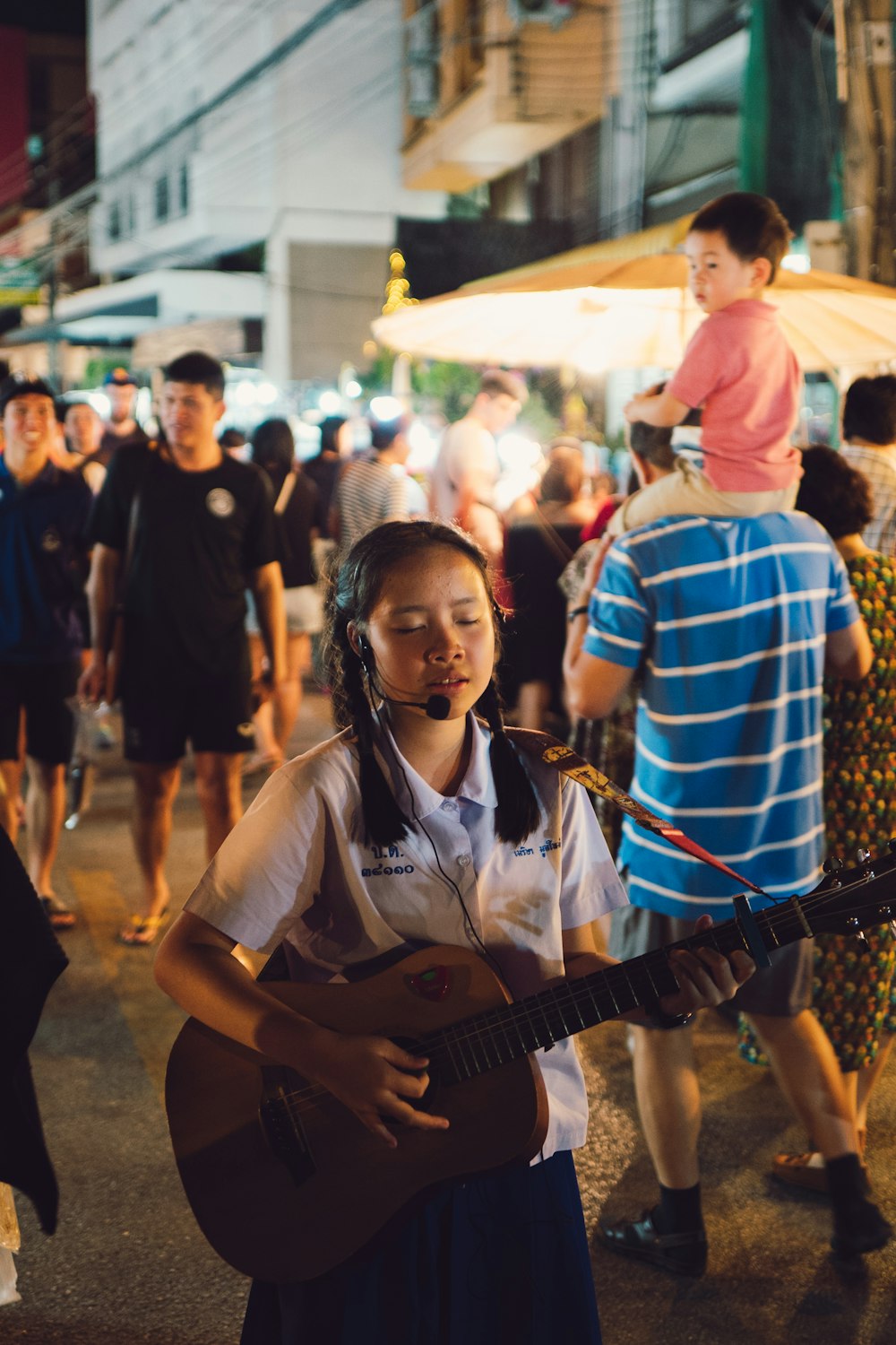 selective focus photo of girl playing guitar and singing