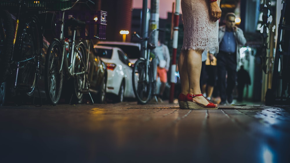 woman standing on street beside parked bikes