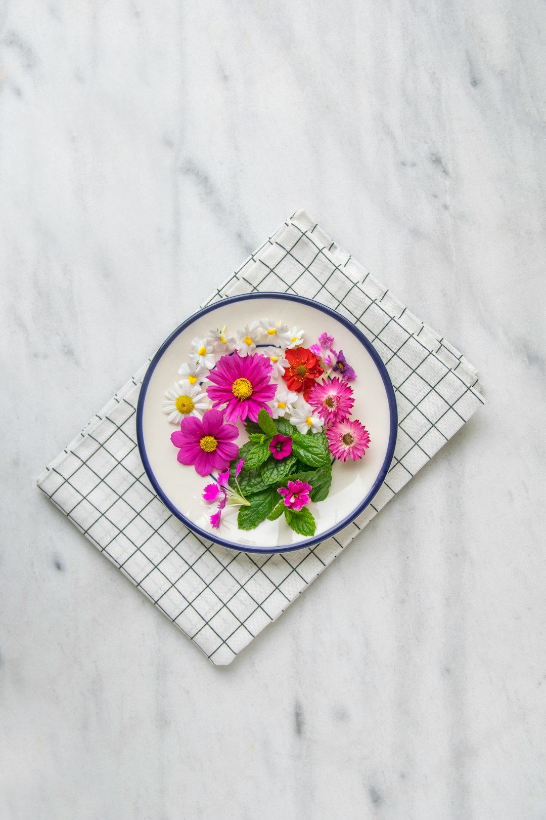  pink petaled flower on white plate tablecloth