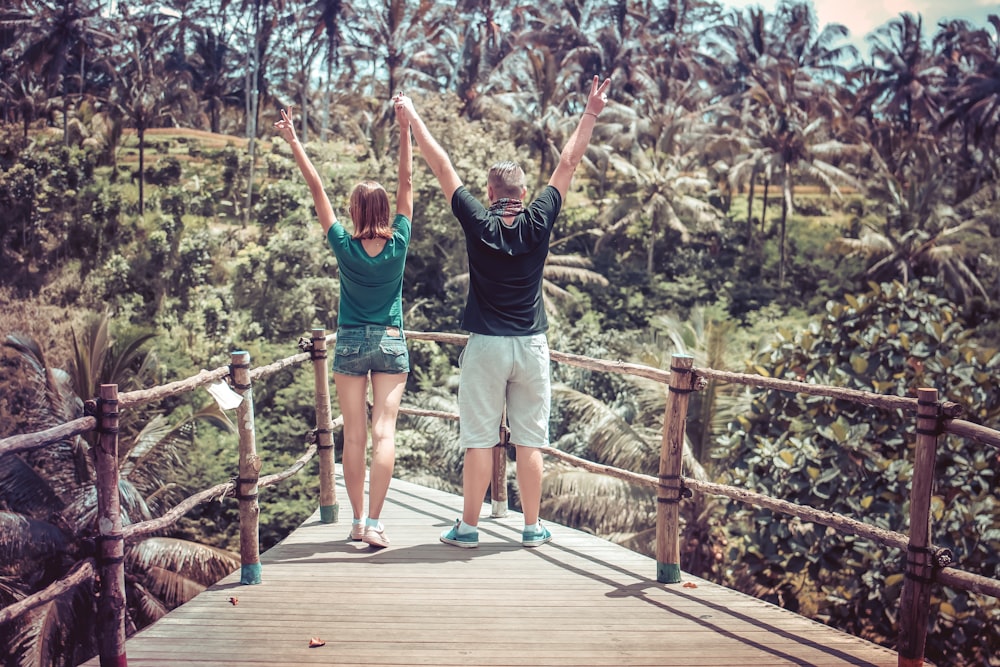 man and woman raising their hands