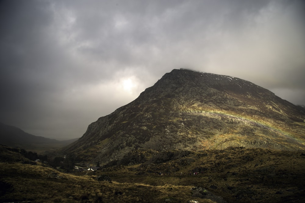 brown mountain peak under white clouds