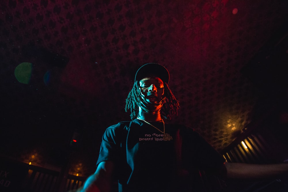 low angle photo of man wearing cap under red ceiling