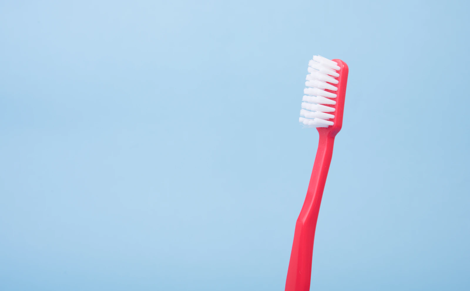 A red toothbrush against a blue background