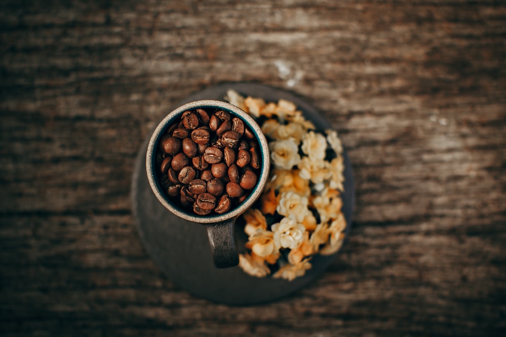 灰色のマグカップに茶色のコーヒー豆