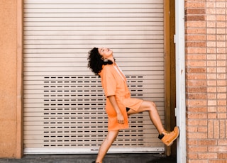 woman stepping her right foot on wall near roller shutter