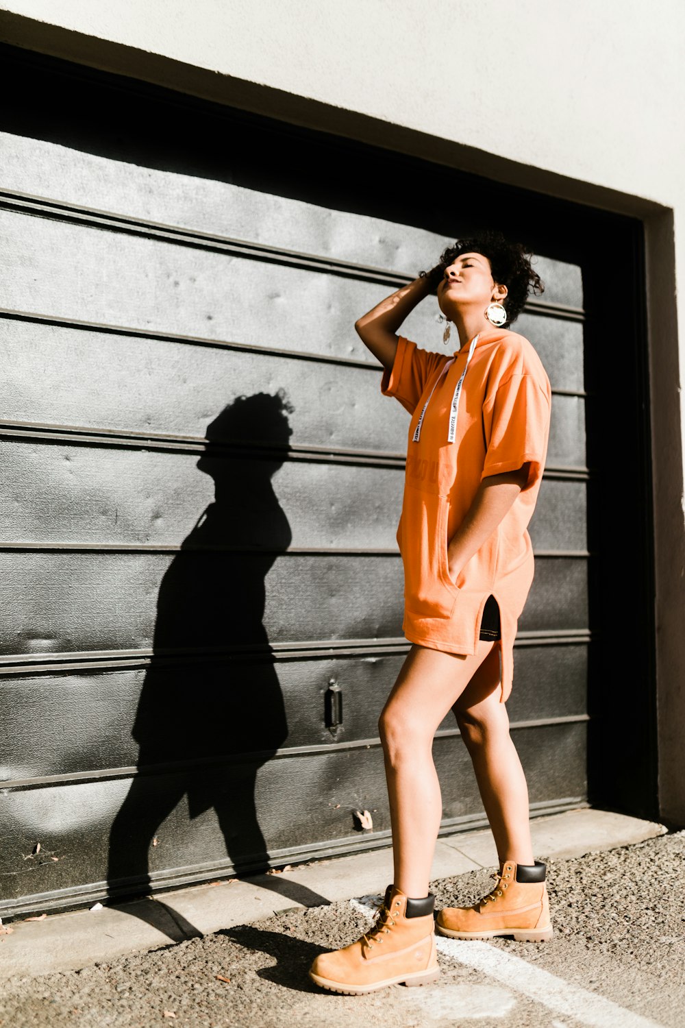 woman standing in front of black roller shutter posing