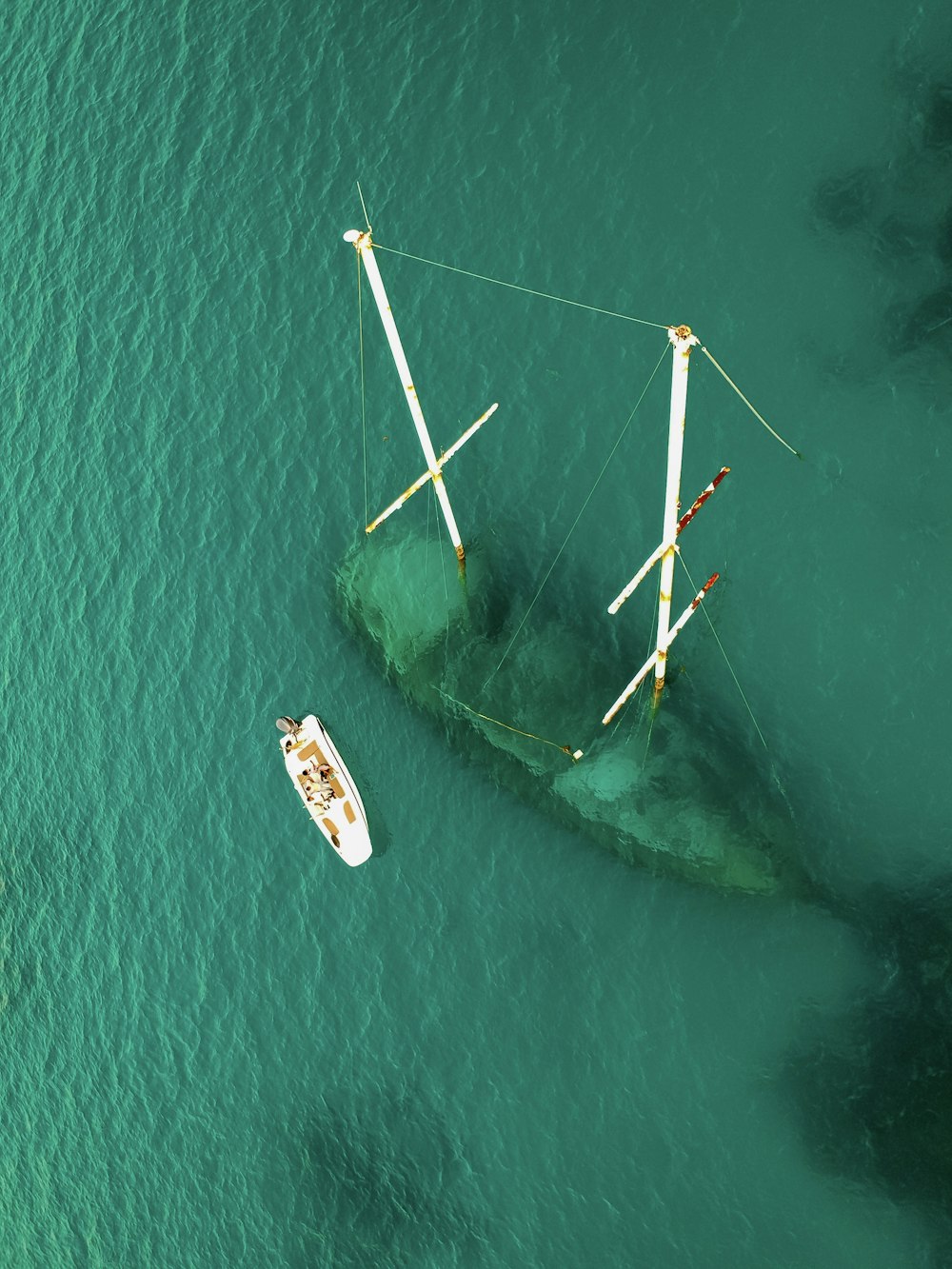 Vue aérienne d’un plan d’eau vert avec un navire coulé