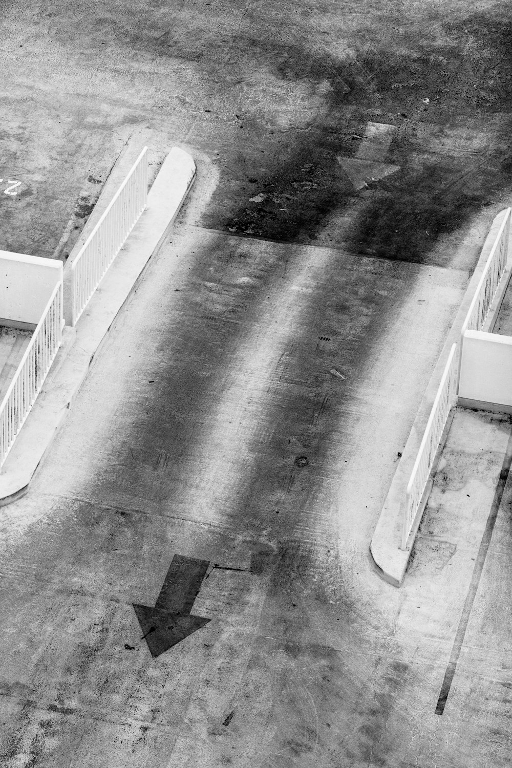fotografia in scala di grigi dell'asta di cemento con le frecce