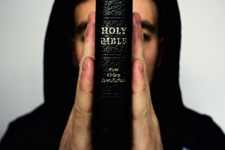 person holding Holy Bible