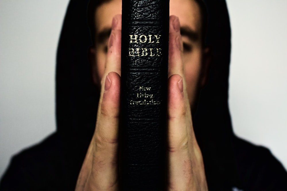 Person, die die Heilige Bibel in der Hand hält