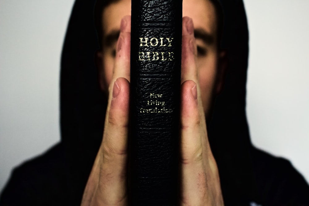 person holding Holy Bible