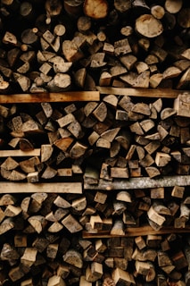 Bundles of compressed firewood stacked on a wooden pallet.