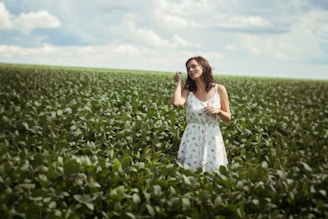 woman standing in green leafed plant field during daytime