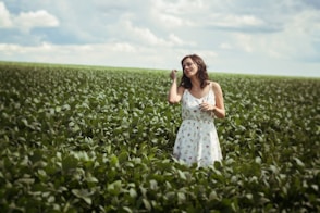 woman standing in green leafed plant field during daytime