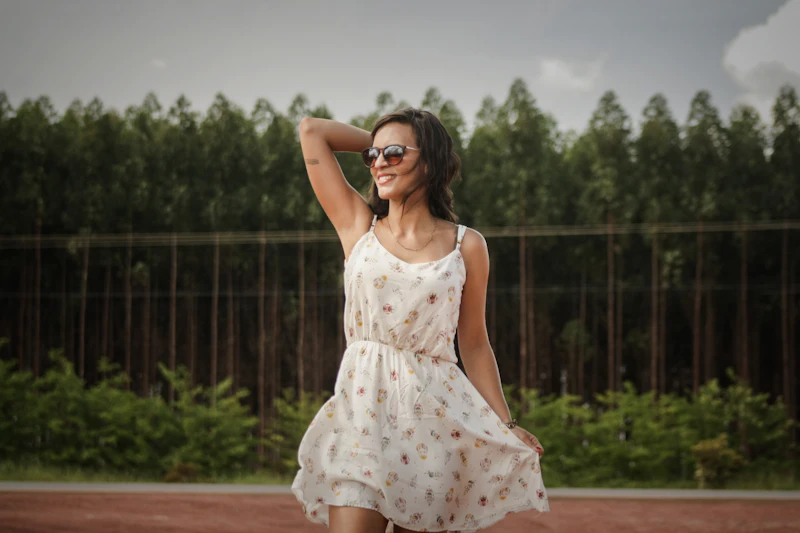 Woman in a white dress outdoors, holding her hair
