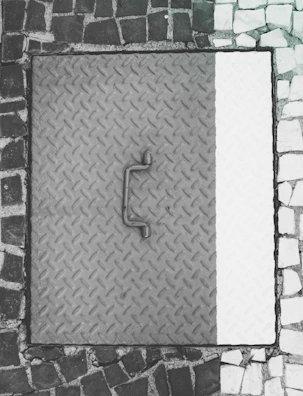 A stack of various manhole covers ready for delivery at a warehouse.