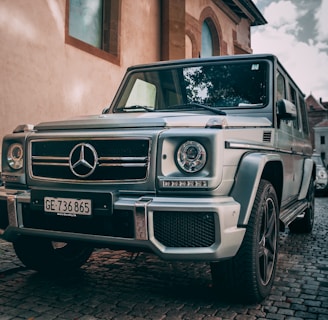 gray Mercedes-Benz vehicle beside house