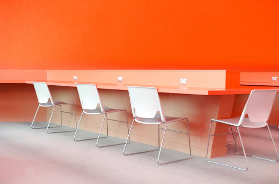 Modern office workspace with sleek navy and orange furniture, bright and inviting atmosphere.