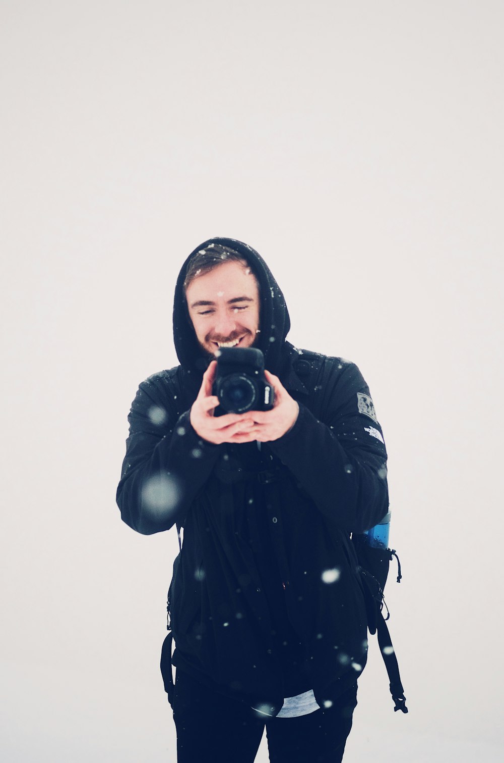 homem sorridente usando câmera DSLR