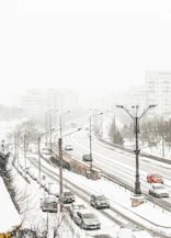 aerial view of road coated snow with vehicle passes