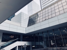A modern architectural scene featuring multiple skyscrapers with a mix of glass and concrete facades. The buildings have geometric designs, and there is a sign for 'First Canadian Place' on one of the structures. The setting conveys a sleek and urban environment.