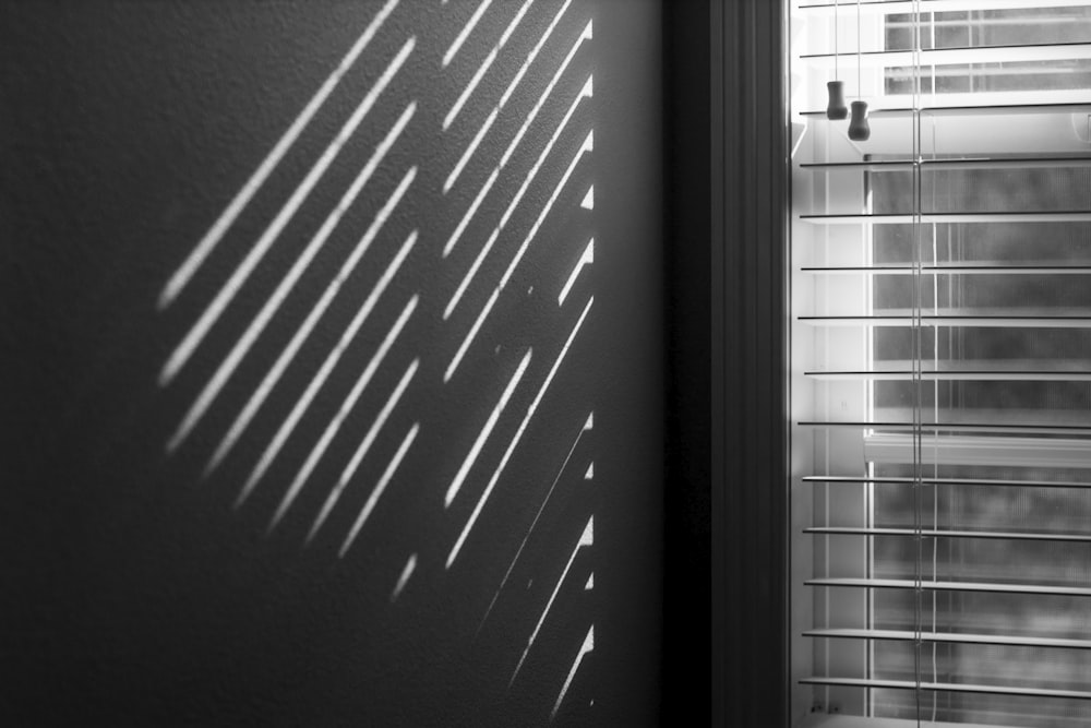 a black and white photo of a window with blinds