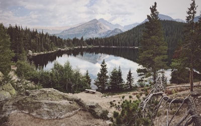 lake between trees near mountain range colorado zoom background