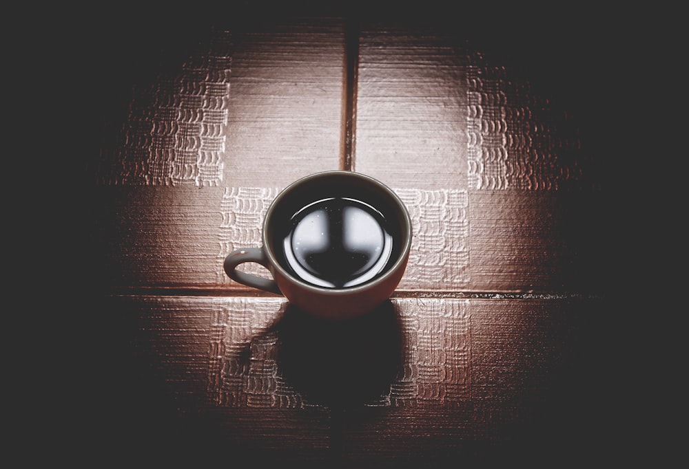 white ceramic teacup on brown surface