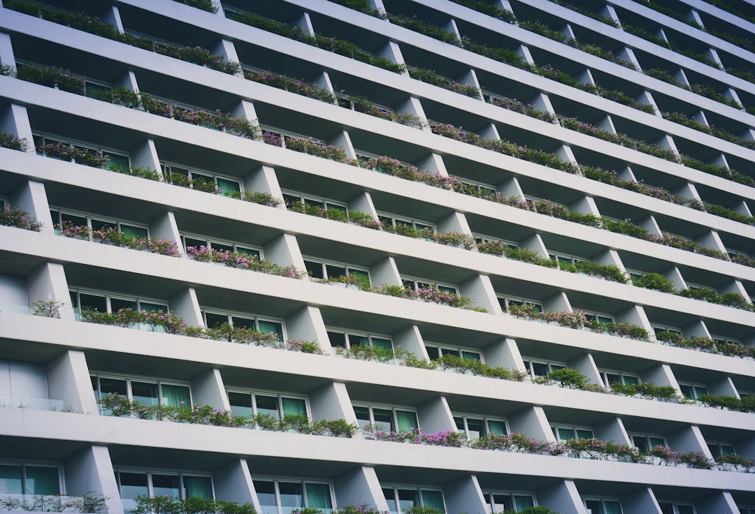 low-angle photography of white building with garden terrace,